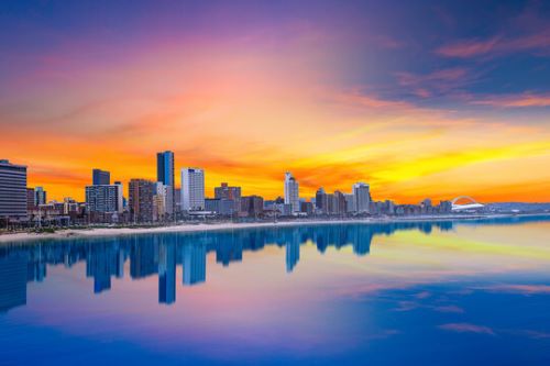 A beautiful skyline picture at sunset with the glassy ocean and hotels in the background